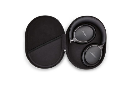 Die Bose Quiet Comfort Ultra Over-Ear-Kopfhörer liegen geöffnet in ihrem schwarzen, ovalen Hartschalentragecase auf weißem Hintergrund. Die Ohrmuscheln zeigen das Bose-Logo.