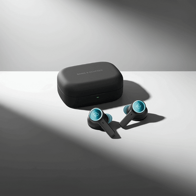 Bang & Olufsen BeoPlay EX True Wireless In-Ear-Kopfhörer in der Farbe Anthracite/Oxygen, die neben ihrem passenden Ladeetui liegen. Die Ohrhörer haben türkisfarbene (Oxygen) Akzente und zeigen das silberne 'B&O'-Logo.